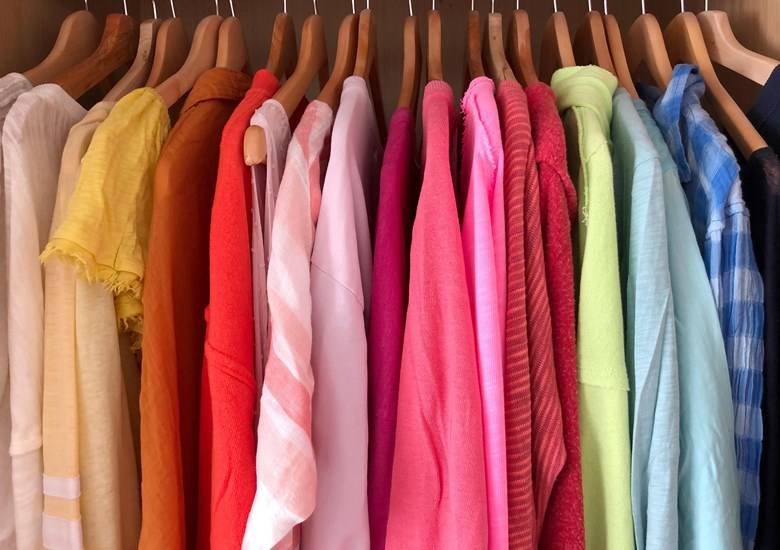 Ganchos de madera con camisas de diferentes colores