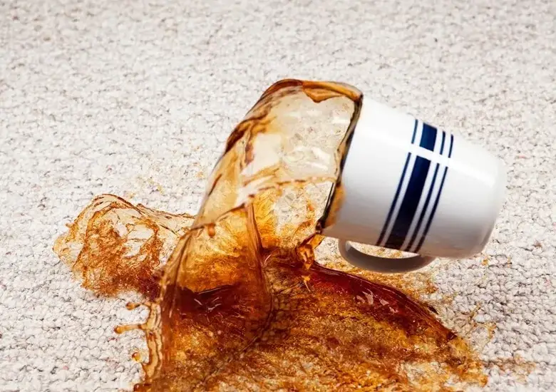 Taza cayendo y derramando café en alfombra de color beige